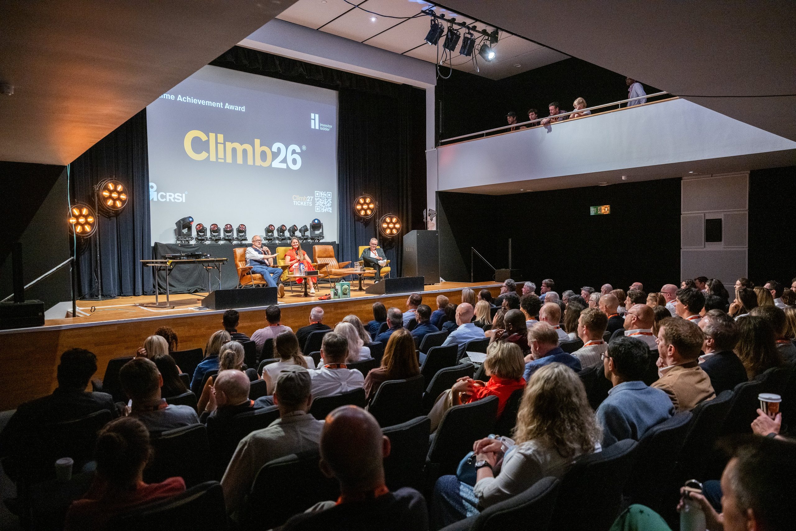 A full audience facing the main stage under the Climb26 screen